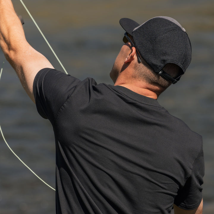 Man wearing corduroy classic cap with performance mesh back outdoors fishing at the lake #color_dark-gray